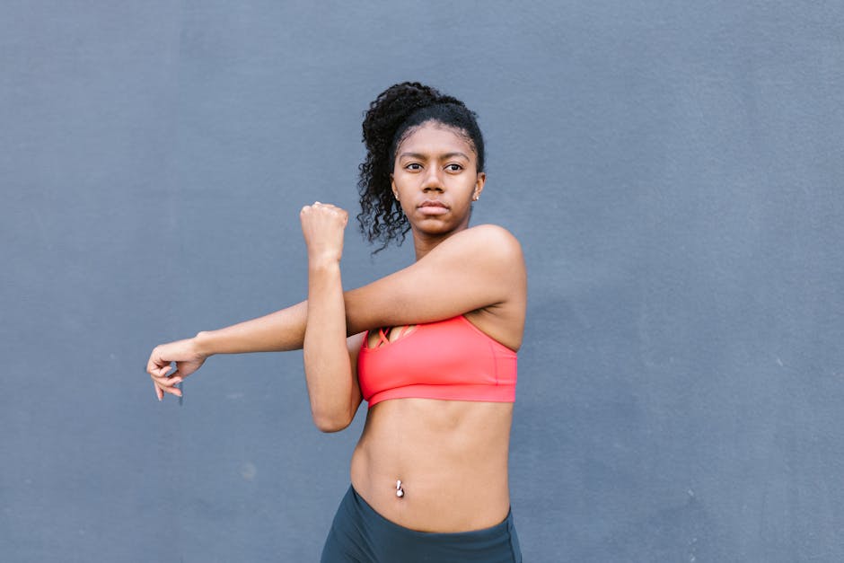 African American woman in activewear stretching outdoors, promoting fitness and healthy lifestyle.