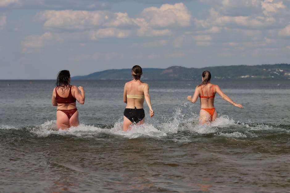 Three women in bikinis having fun in the water at Jönköping beach, Sweden.