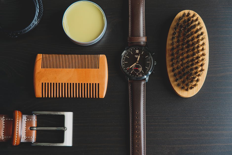 Flat lay of men's grooming accessories including watch, brush, comb, and pomade.
